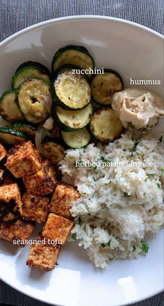 a white plate topped with rice, zucchini and other food items on top of it