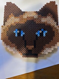 an animal made out of perler beads on top of a white piece of paper