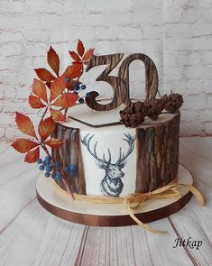 a cake decorated with an image of a deer and the number 30 on it is surrounded by autumn leaves