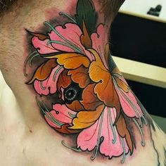 a man's neck with a flower tattoo design on the back of his neck