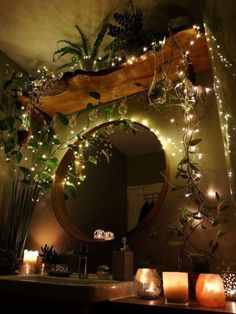 a mirror and some candles on a counter in a room with lights hanging from the ceiling