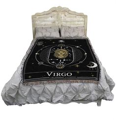 a bed with a black and white blanket on it's headboard, which has the zodiac sign pisces on it