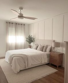 a bedroom with a bed, dresser and ceiling fan in the middle of the room