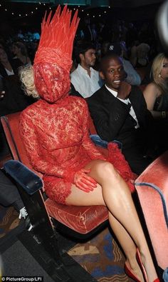 a woman in a red dress sitting next to a man