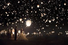 a bride and groom standing in front of floating lanterns with the words i'm doing this at my wedding