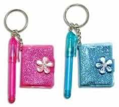 three different colored key chains with small items on them, one has a pen and the other has a flower