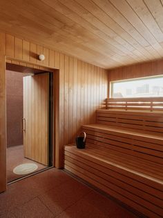 a sauna room with wooden walls and steps leading up to the bathroom door area