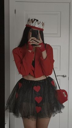 a woman taking a selfie wearing a red jacket and black tutu skirt with hearts on it