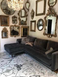 a living room filled with furniture and lots of mirrors on the wall next to it