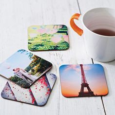 the eiffel tower coasters are next to a cup of tea and coffee