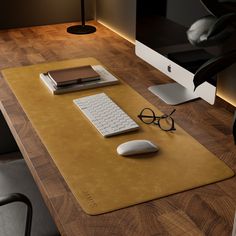 a computer desk with a keyboard, mouse and glasses on it in front of a monitor