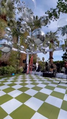 an outdoor dance with disco balls hanging from the ceiling and palm trees in the background