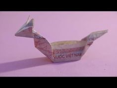 an origami bird made out of paper on a pink background with the words vuoc vietnam printed on it