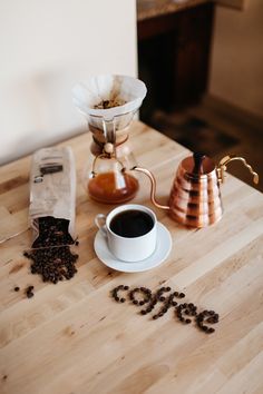 a cup of coffee sitting on top of a wooden table