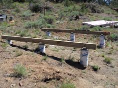 three buckets are sitting on top of a bench in the middle of a field