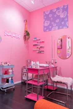 a room with pink walls and lots of items on the table in front of it