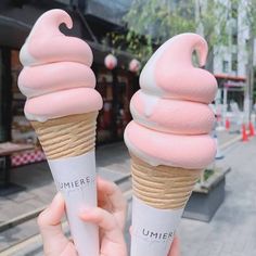 two ice cream cones with pink icing on top