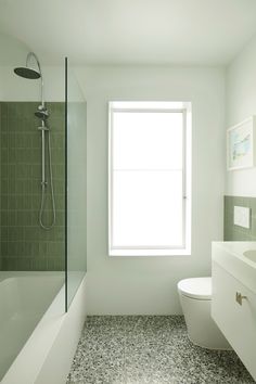 a bathroom with green tile and white fixtures