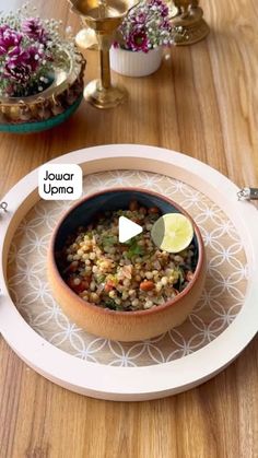 a bowl filled with food sitting on top of a wooden table next to a plate