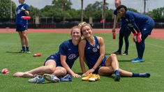 two women sitting on the ground with their arms around each other