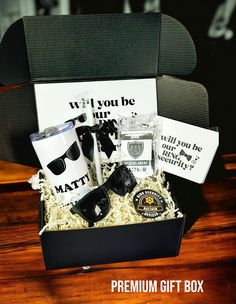 a gift box with sunglasses, coffee mugs and other personalized items in it