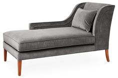 a gray chaise lounge chair with two pillows on the armrests and back