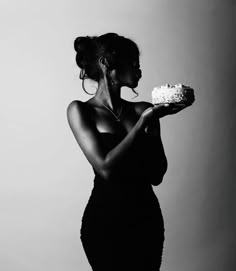 a black and white photo of a woman holding a cake