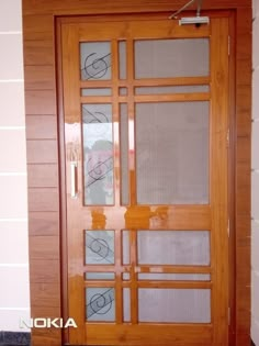 a wooden door with glass panels on the side