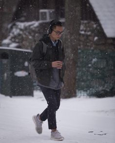 a man walking in the snow with headphones on