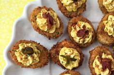 small appetizers are arranged on a white platter with yellow and green background