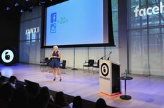 a woman standing on stage in front of a projector screen