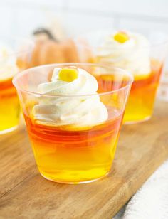 cupcakes with white frosting and yellow sprinkles in small cups