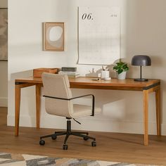 a desk with a chair and a calendar on the wall