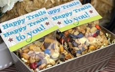 there are two tins filled with treats on top of a table that says happy trails