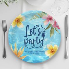 a party plate with flowers on it next to silverware and utensils,