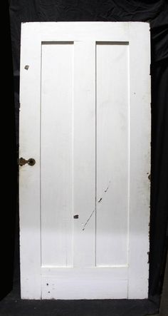 an old white door sitting on top of a black backdrop