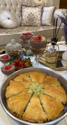 a pie sitting on top of a table next to some strawberries and other desserts