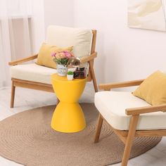 two wooden chairs sitting next to each other on top of a rug in a living room