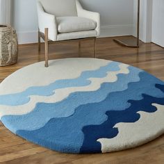 a blue and white rug with waves on it in a living room next to a chair