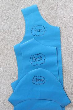 three blue aprons with writing on them sitting on the floor next to each other