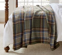 a bed with a plaid blanket on top of it