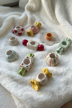 small tea cups and saucers sitting on a white towel next to a cup holder