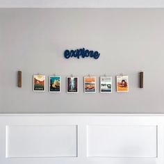 a wall with pictures hanging on it and the word explore spelled in blue above them