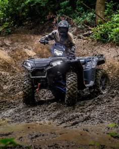 a person riding an atv in the mud