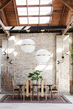 a dining room with brick walls and wooden tables, hanging lights and plants on the wall