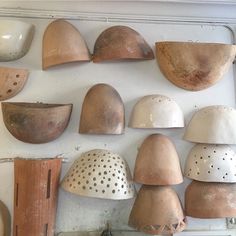 many different types of helmets are hanging on the wall