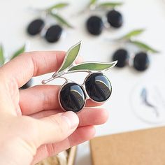 a person holding some black berries in their hand