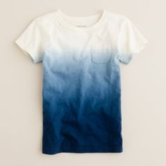 a white and blue t - shirt hanging on a wall