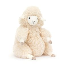 a white stuffed sheep sitting on the ground