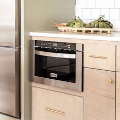 a kitchen with stainless steel appliances and wooden cabinetry, including a dishwasher